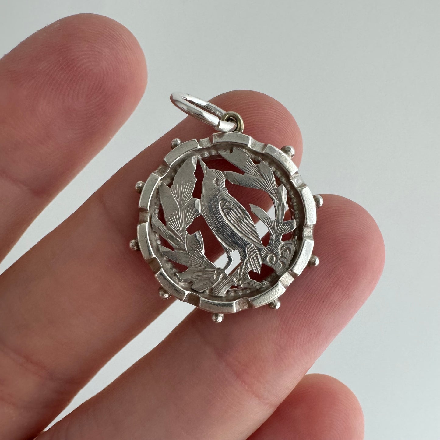 A N T I Q U E // the lookout / sterling silver bird and foliage in a detailed round frame / a pendant