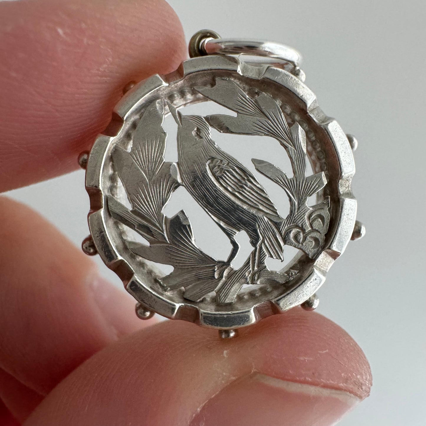 A N T I Q U E // the lookout / sterling silver bird and foliage in a detailed round frame / a pendant